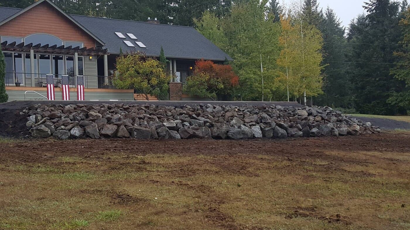 Finished property with rock retaining wall and home